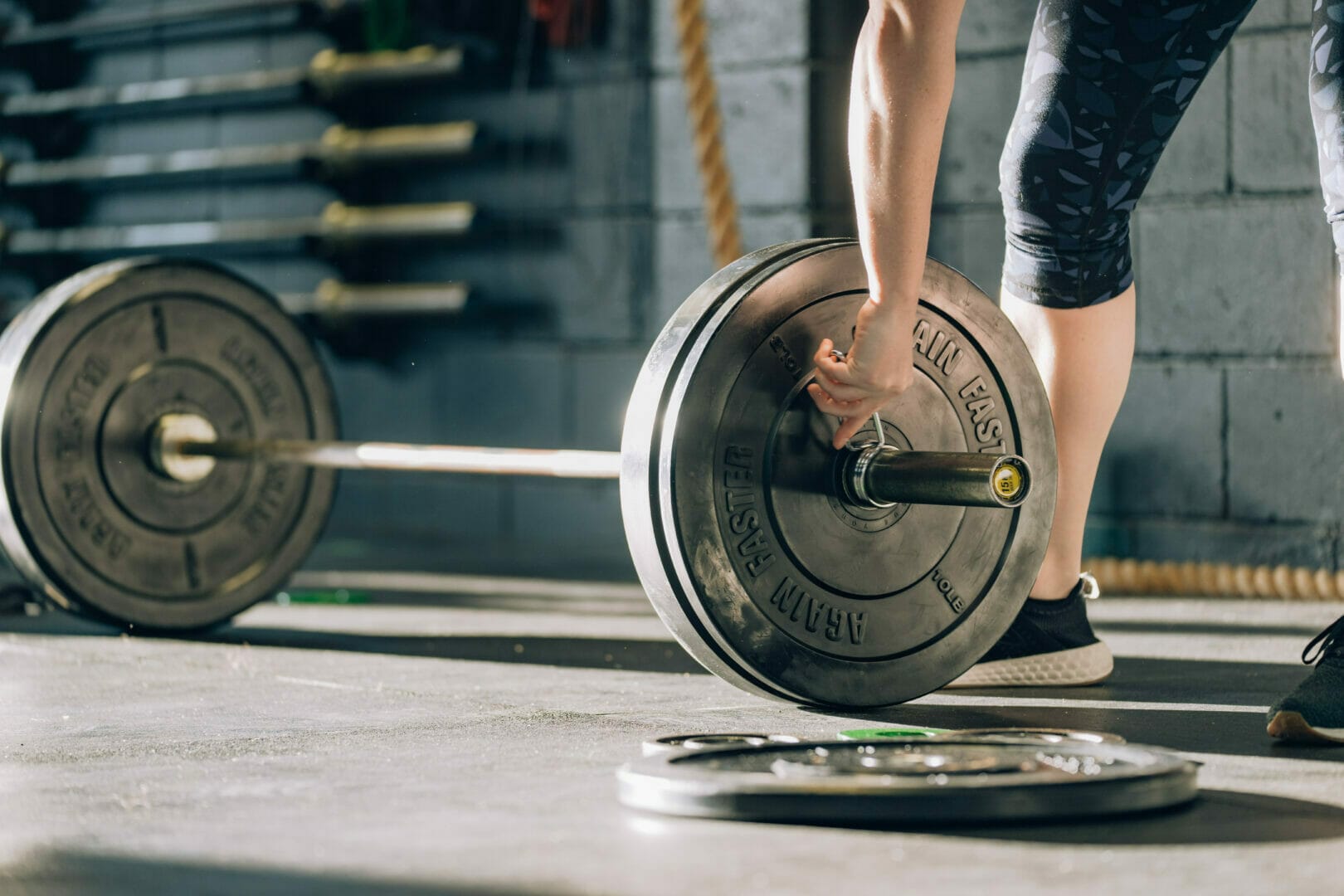 a person putting a collar to the 10 lb barbell plates