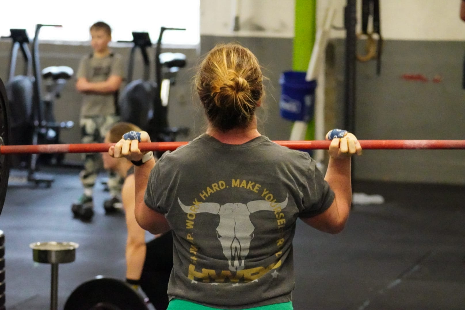 women lifting a barbell at a gym